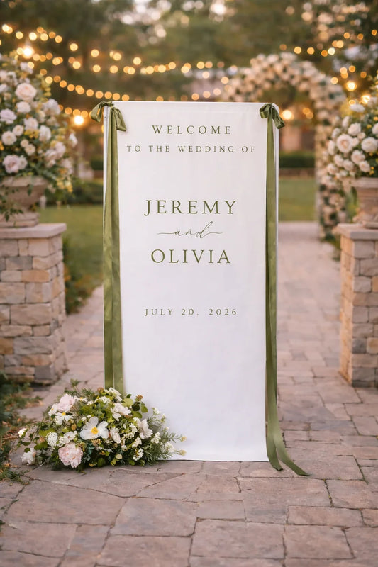 Wedding welcome sign with 'Jeremy and Olivia' at an outdoor wedding venue.