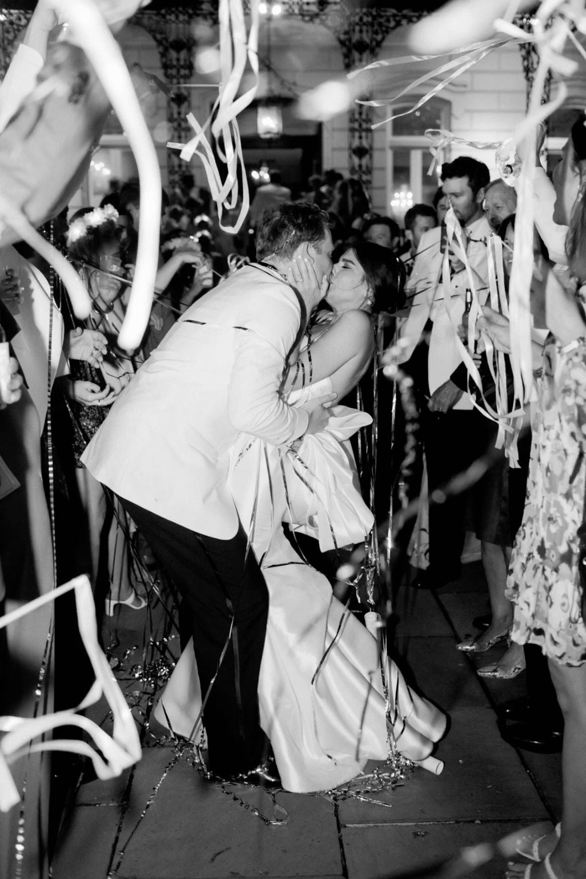 Two people kissing on a dance floor with festive decorations